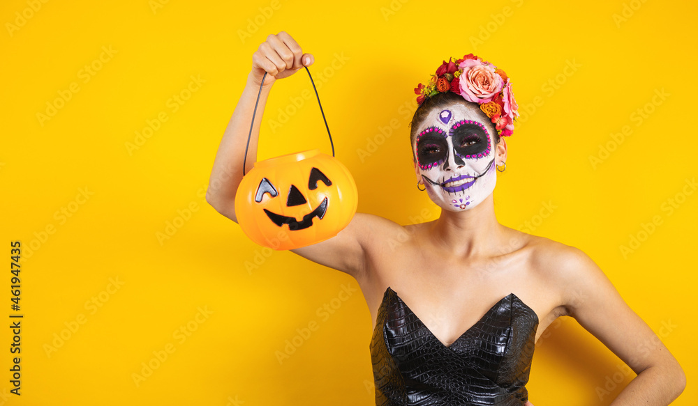 Mexican Catrina, portrait of young latin woman holding a plastic calaverita pumpkin for Halloween party in Mexico Mexican Catrina, portrait of young latin woman holding a plastic calaverita pumpkin for Halloween party in Mexico
