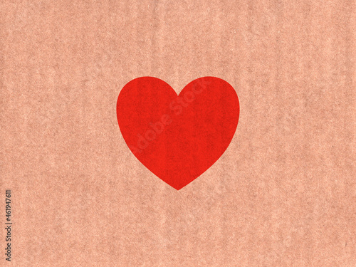 Red heart icon on cardboard texture