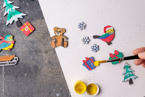 the process of painting wooden toys for the Christmas tree
