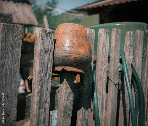 An old clay pot on the wooden fence