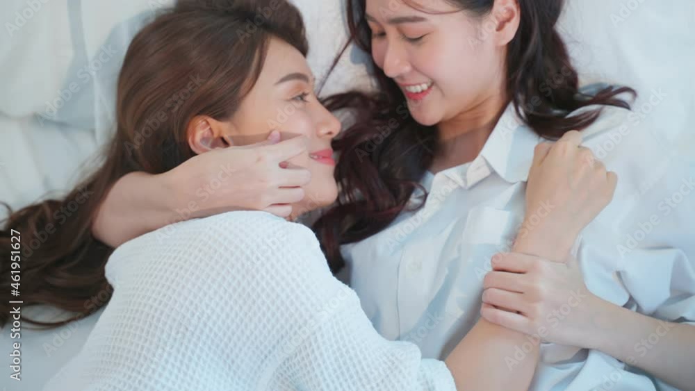 Asian beautiful lesbian couple lying down on bed and hugging each other. Asian beautiful lesbian couple lying down on bed and hugging each other.