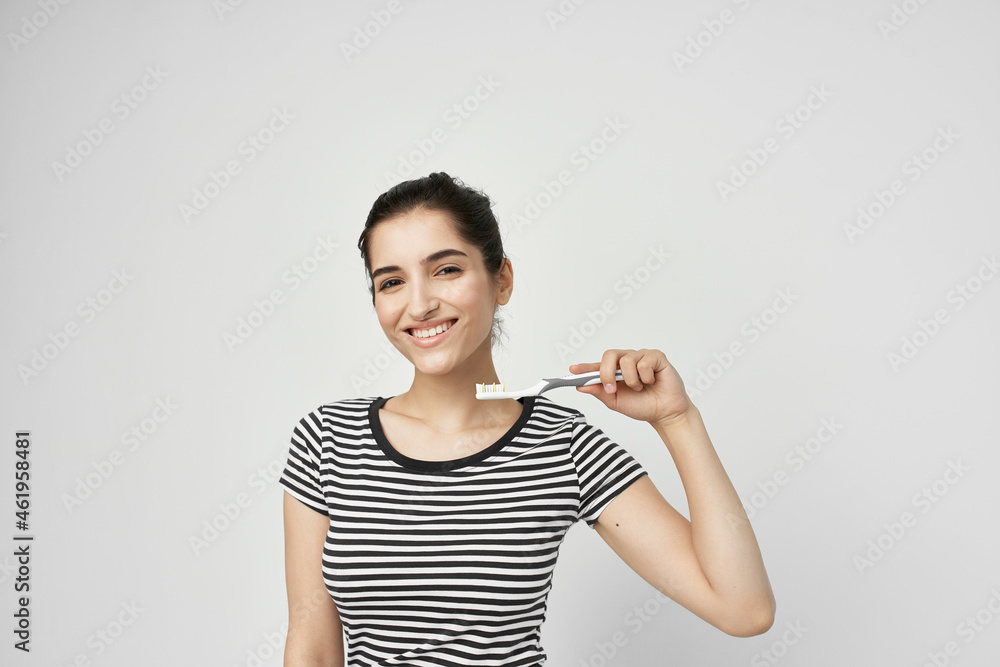 brunette brush your teeth with a toothbrush light background brunette brush your teeth with a toothbrush light background
