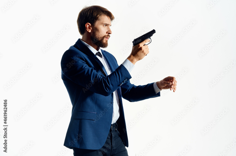 Man gun in the hands of the mafia emotions Agent light background