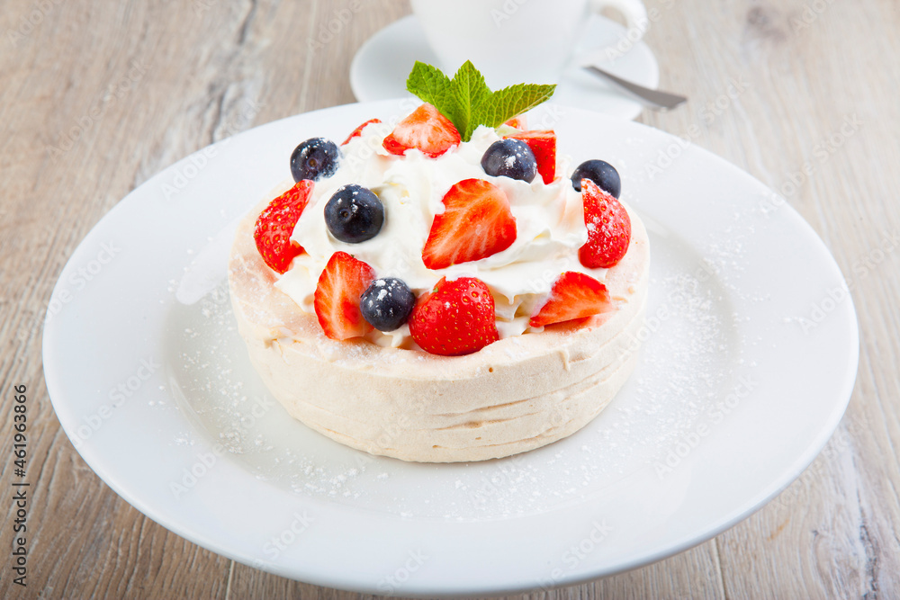 Pavlova dessert on a white plate with a cup Pavlova dessert on a white plate with a cup