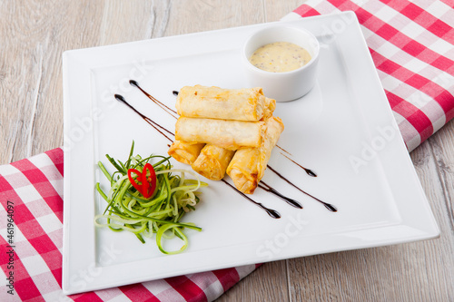 cheese sticks with cucumber cheese sauce on a white plate