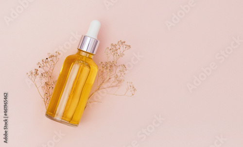 glass bottle with serum on a light background with sun glare