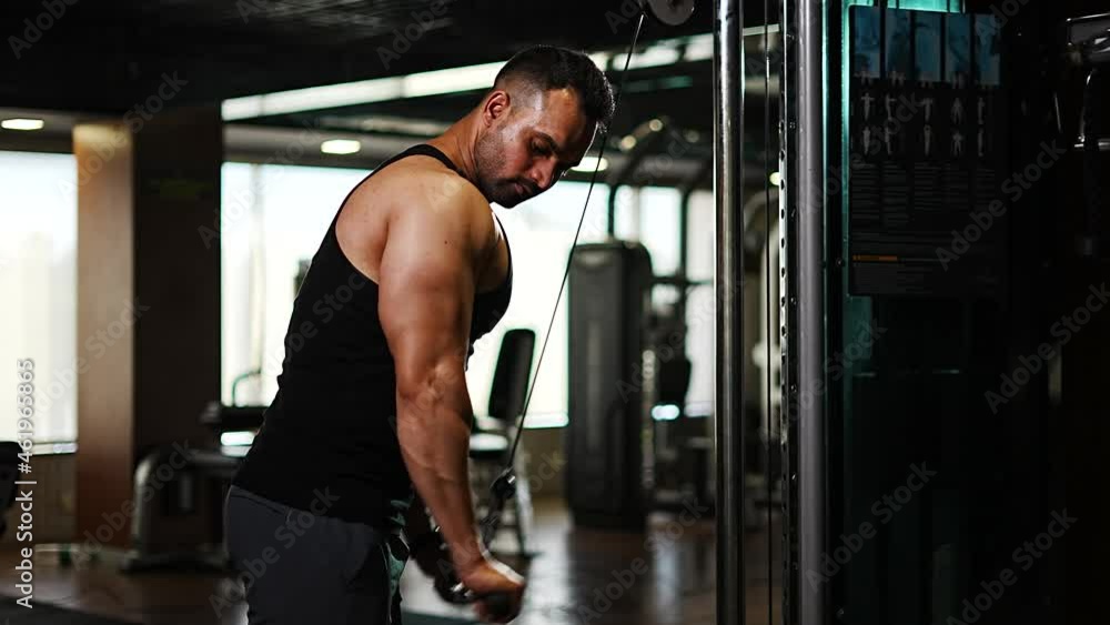 professional athlete bodybuilder working out in the indoor gym. weight lifting and bodybuilding, muscle strengthening workout. man doing triceps exercise for fitness. professional athlete bodybuilder working out in the indoor gym. weight lifting and bodybuilding, muscle strengthening workout. man doing triceps exercise for fitness.