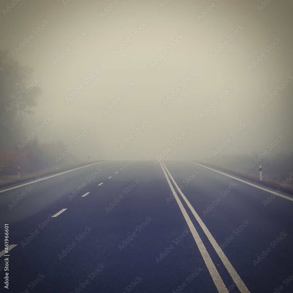 Bad weather driving - foggy hazy country road. Motorway - road traffic. Winter time.