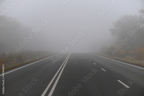 Bad weather driving - foggy hazy country road. Motorway - road traffic. Winter-autumn time.