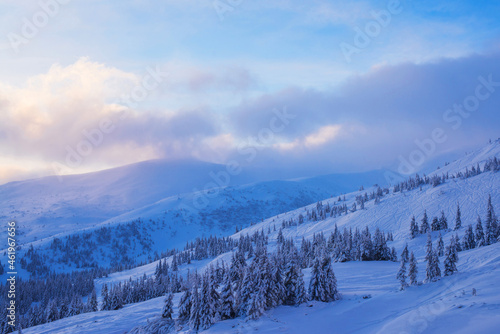 Snow-covered mountain slopes against the backdrop of sunrise.