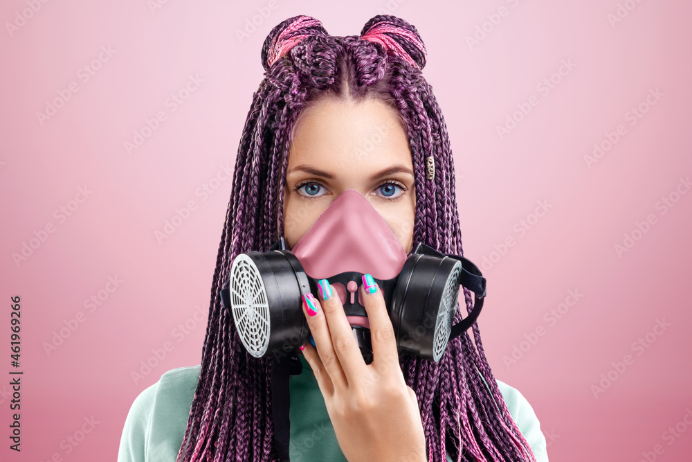Obraz premium A beautiful girl with a hairstyle of pink braids with a burst on her face posing on a pink background in the studio. The concept is modern style, individuality, inclusiveness, creativity.