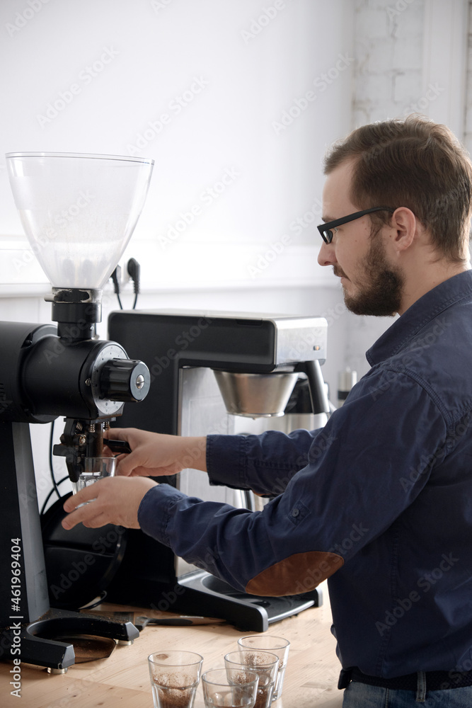 Grinding fresh coffee into glass cups for cupping Grinding fresh coffee into glass cups for cupping