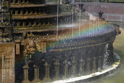 A rainbow is located on the fountain cascade.