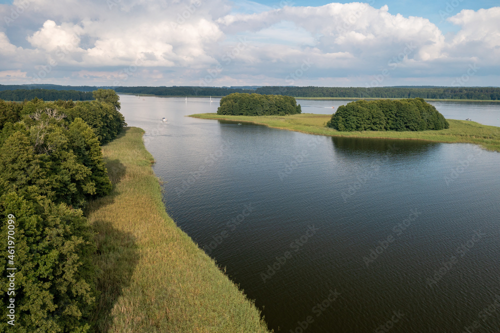 Fototapeta premium Aerial view of green islands and clouds at summer sunny day. Masurian Lake District in Poland.