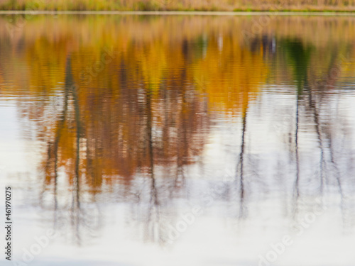Autumn color is reflected in the still water of the lake