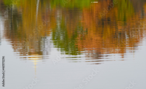 Autumn color is reflected in the still water of the lake