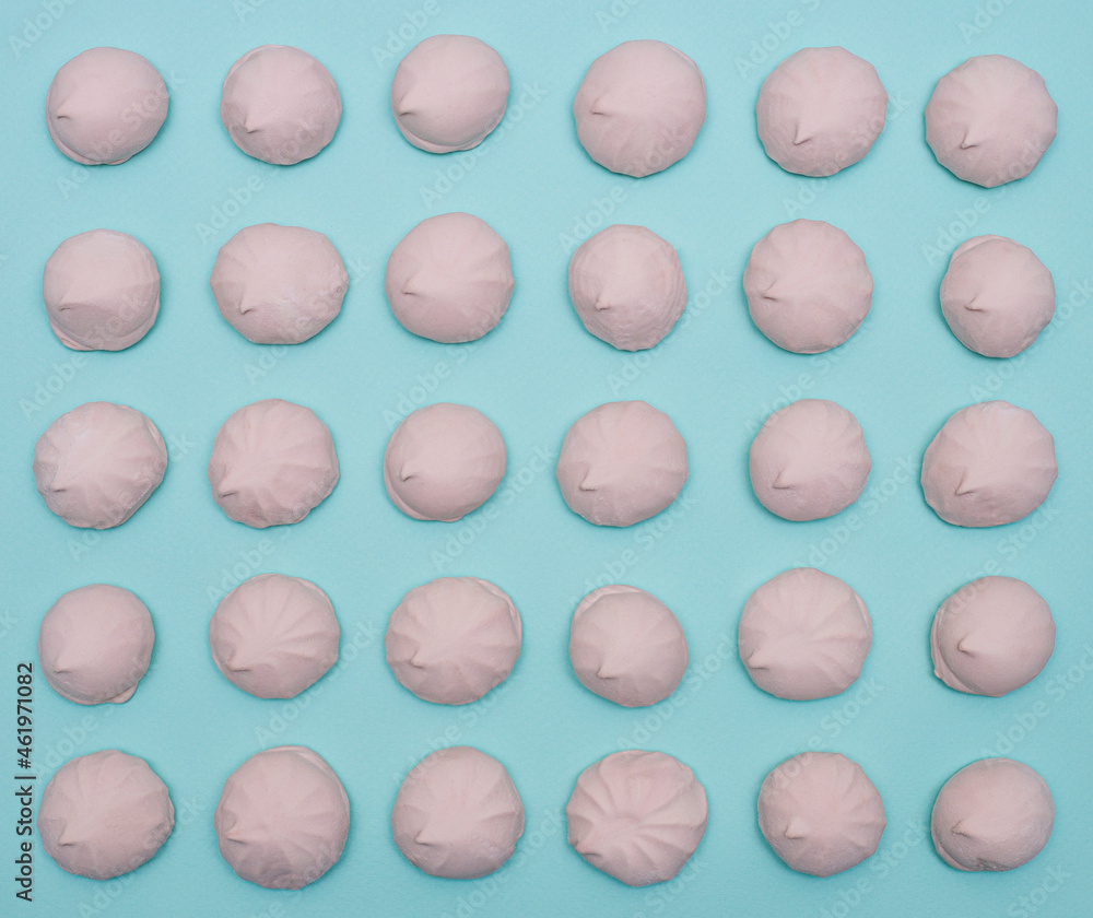 A pattern of pink marshmallows on blue paper. A pattern of pink marshmallows on blue paper.