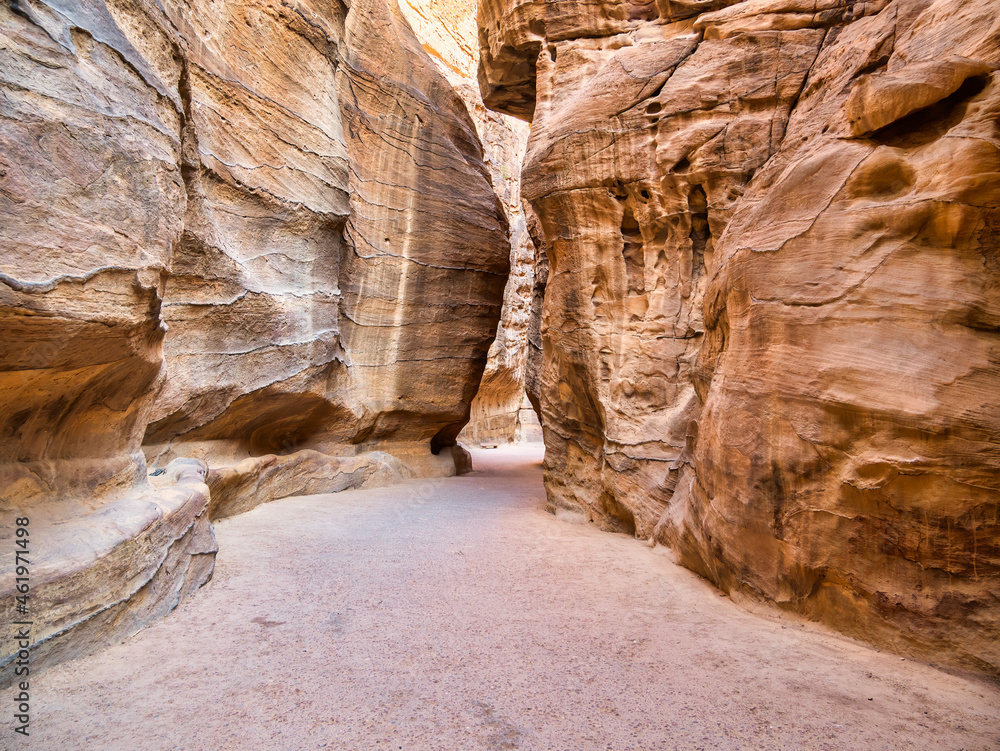 Picture with al-Siq, the natural passage through red rock walls which is main entrance to the ancient Nabatean city of Petra in southern Jordan.