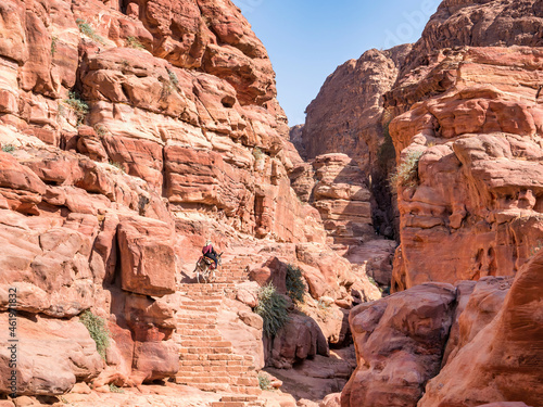 Arab woman riding a donkey on the Ed-Deir Trail  monastery trail  in the ancient city of Petra  Jordan.