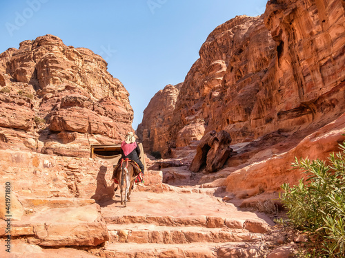 Arab woman riding a donkey on the Ed-Deir Trail (monastery trail) in the ancient city of Petra, Jordan.