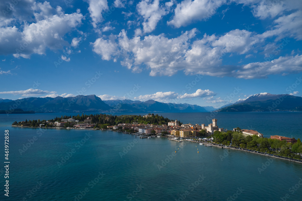 Aerial view of the island of Sirmione. Sirmione, Lake Garda, Italy. Panorama of Lake Garda. Peninsula on a mountain lake in the background of the alps. Castle on the water in Italy.