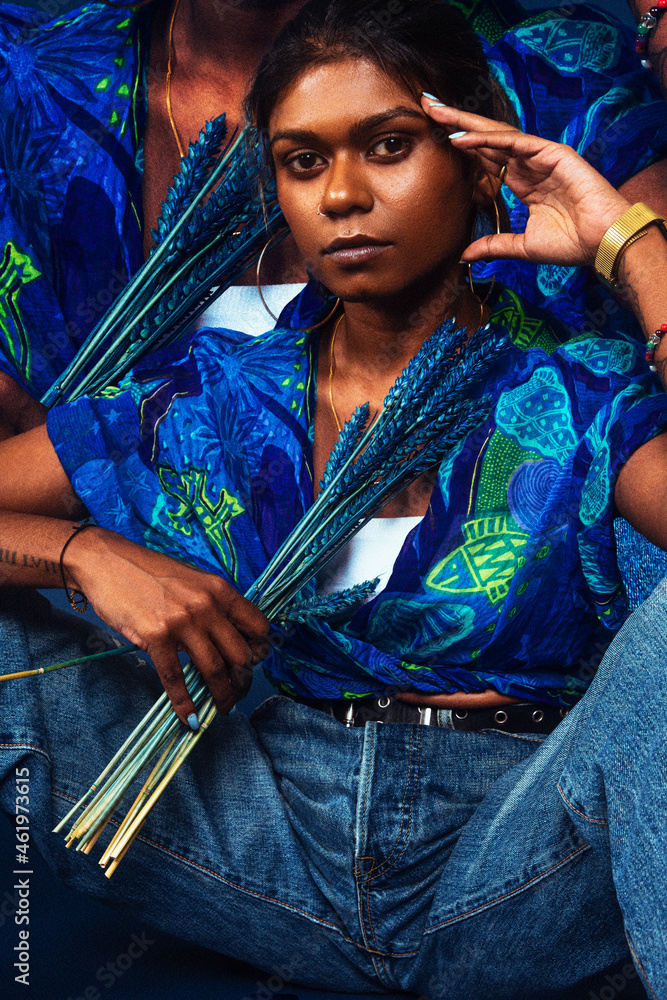 portrait of dark skinned Indian woman from Malaysia against a dark blue ...