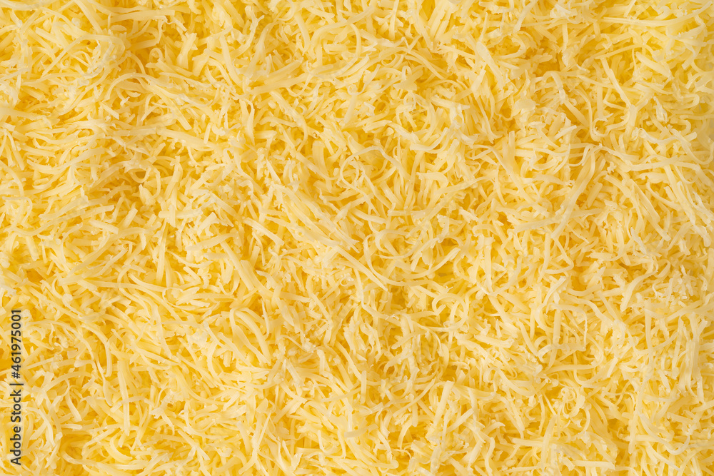 Obraz premium Grated cheese background texture. yellow shredded cheese. Close up top view.