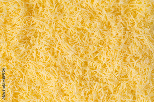 Grated cheese background texture. yellow shredded  cheese. Close up top view.