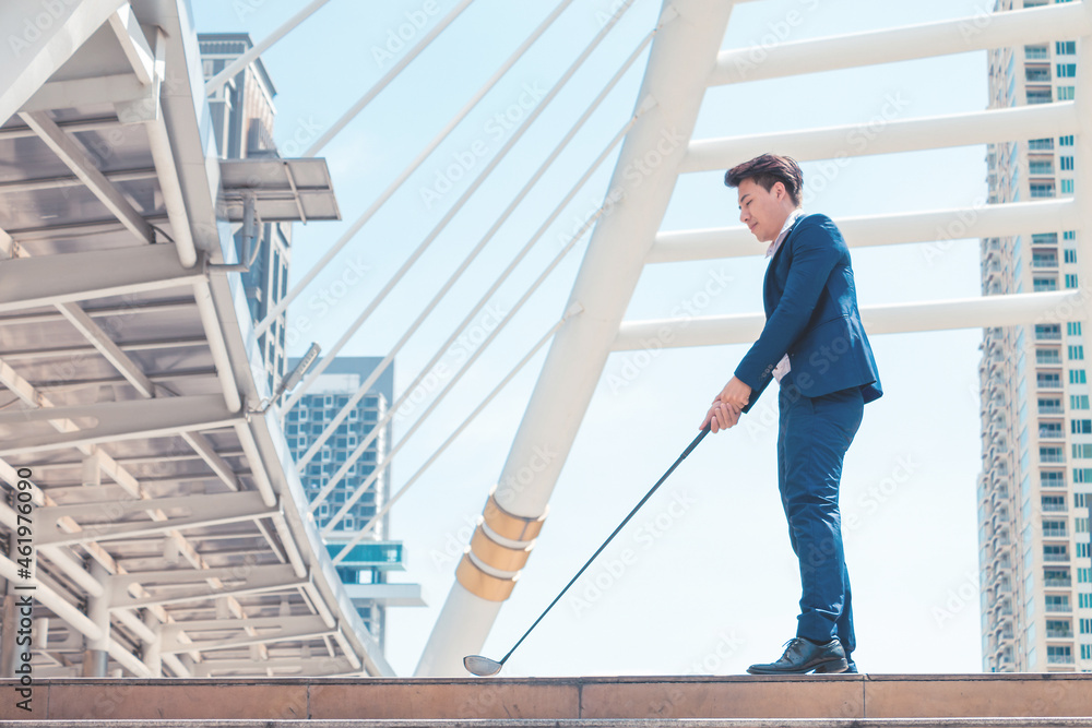 Young successful businessman playing golf with cityscape background. Business target concept.