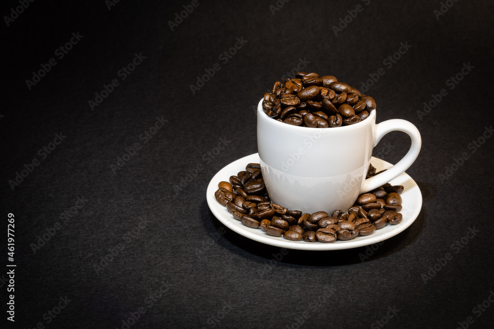 white espresso cup filled with roasted coffee beans white espresso cup filled with roasted coffee beans