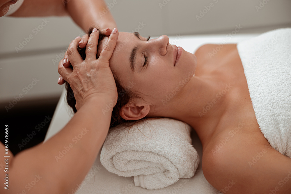 Charming woman receiving professional scalp massage in spa salon Charming woman receiving professional scalp massage in spa salon