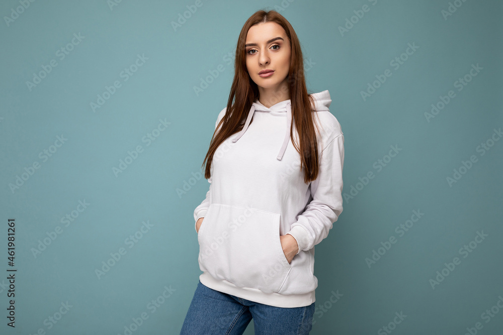 Young beautiful brunette woman with sincere emotions isolated on background wall with copy space wearing casual stylish light colour hoodie. Positive concept Young beautiful brunette woman with sincere emotions isolated on background wall with copy space wearing casual stylish light colour hoodie. Positive concept