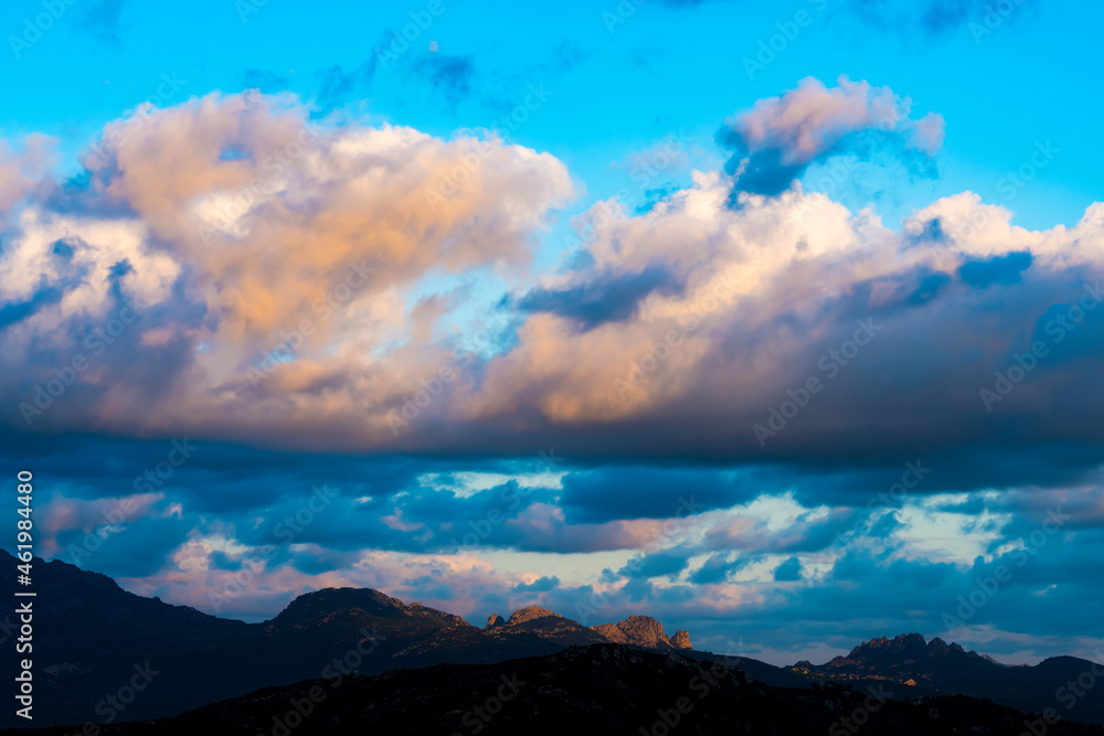 Stunning view of a dark, shadowy mountain range during a dramatic and cloudy sunrise. San Pantaleo, Sardinia, Italy. Stunning view of a dark, shadowy mountain range during a dramatic and cloudy sunrise. San Pantaleo, Sardinia, Italy.