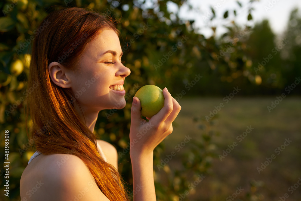 Woman in a white dress in a field with apples in her hands Woman in a white dress in a field with apples in her hands