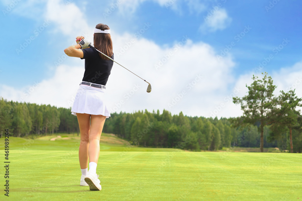 Woman golfer hits an fairway shot towards the club house. Woman golfer hits an fairway shot towards the club house.
