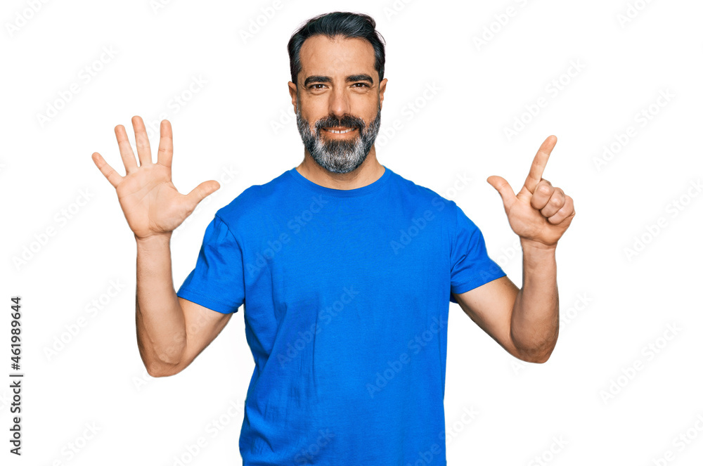 Middle aged man with beard wearing casual blue t shirt showing and pointing up with fingers number seven while smiling confident and happy. Middle aged man with beard wearing casual blue t shirt showing and pointing up with fingers number seven while smiling confident and happy.