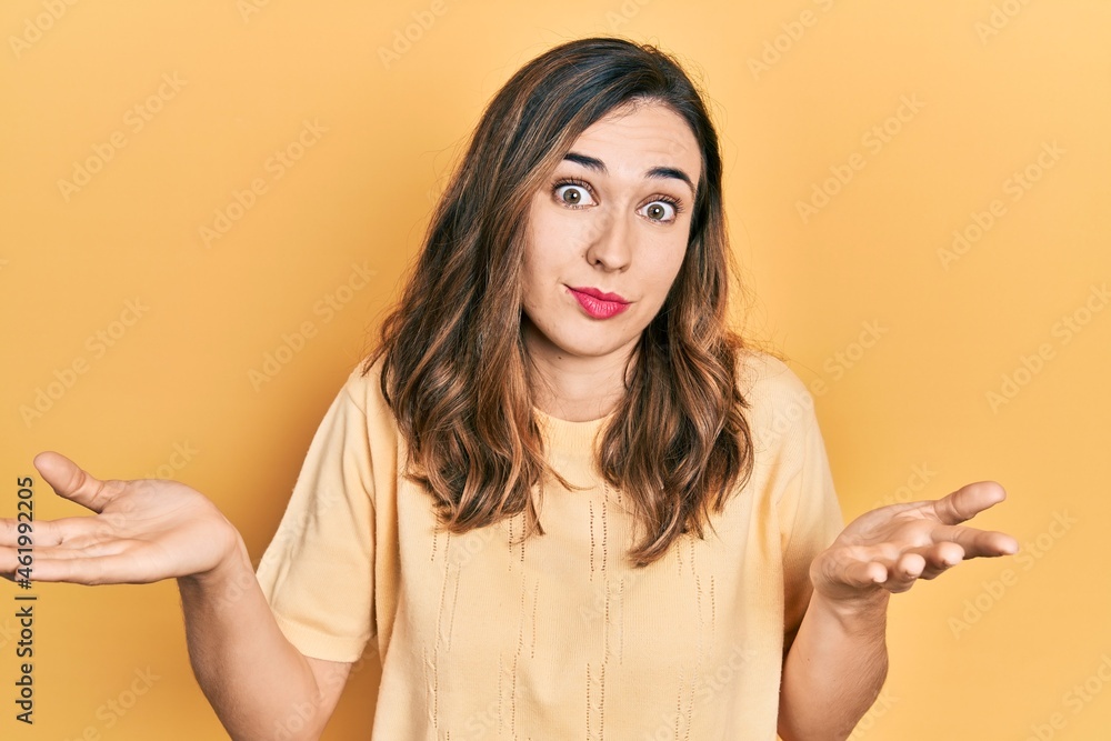 Young hispanic girl wearing casual clothes clueless and confused expression with arms and hands raised. doubt concept. Young hispanic girl wearing casual clothes clueless and confused expression with arms and hands raised. doubt concept.