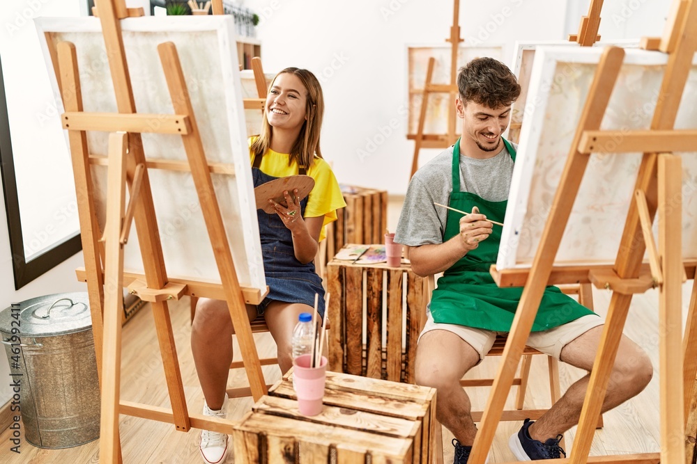 Obraz premium Young hispanic artist couple smiling happy drawing at art studio.