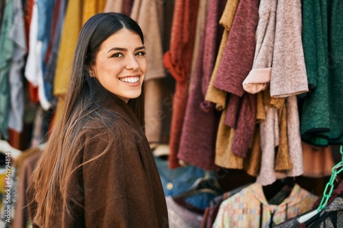 Young hispanic woman smiling happy shopping at the city.