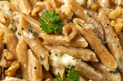 Whole Wheat Penne pasta with gorgonzola cheese sauce, spinach and walnut. Healthy food.