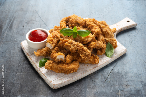 Obraz na plátně Fried Chicken strips with ketchup on white wooden board