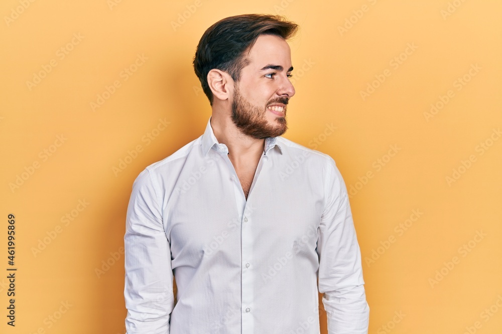 Handsome caucasian man with beard wearing business white shirt looking to side, relax profile pose with natural face and confident smile. Handsome caucasian man with beard wearing business white shirt looking to side, relax profile pose with natural face and confident smile.