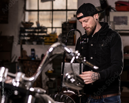 Biker schraubt an seinem Motorrad, Custombikes, Motorrad, Tätowierter Mann mit Bart © fuchs mit foto