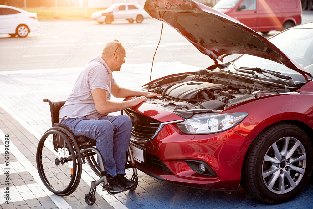 person with a physical disability check engine his car at parking person with a physical disability check engine his car at parking