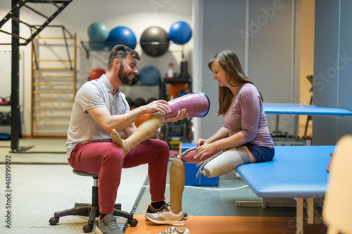 Physiotherapist helping young woman with prosthetic legs
 photo