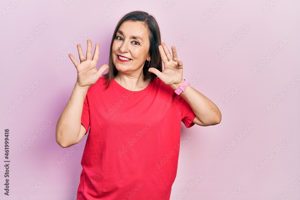 Middle age hispanic woman wearing casual clothes showing and pointing up with fingers number nine while smiling confident and happy. Middle age hispanic woman wearing casual clothes showing and pointing up with fingers number nine while smiling confident and happy.