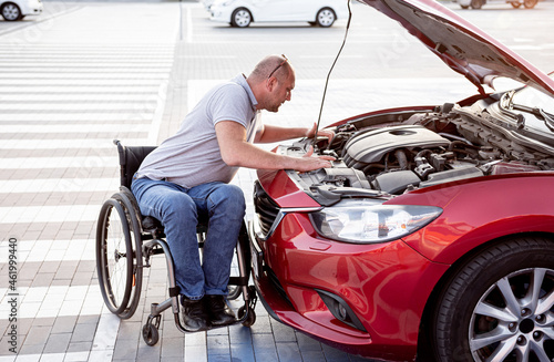 person with a physical disability check engine his car at parking © romaset