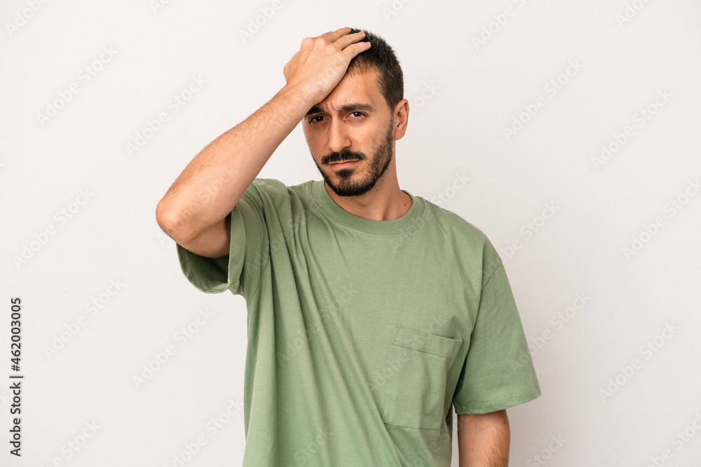 Obraz premium Young caucasian man isolated on white background forgetting something, slapping forehead with palm and closing eyes.