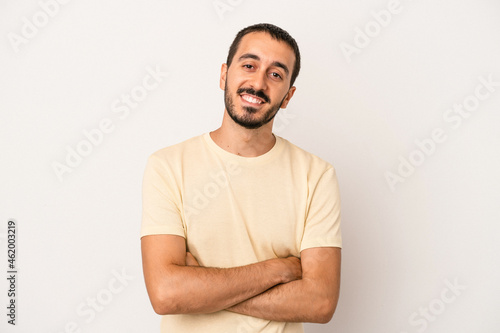 Young caucasian man isolated on white background who feels confident, crossing arms with determination.