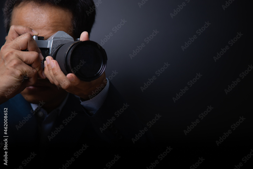 Fototapeta premium professional male photographer shooting indoor on vitage camera